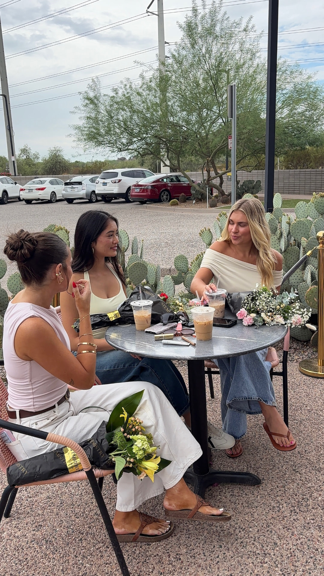 Guests talking over iced coffees and wrapped bouquets on the cactus-lined patio at Stemistry South Scottsdale