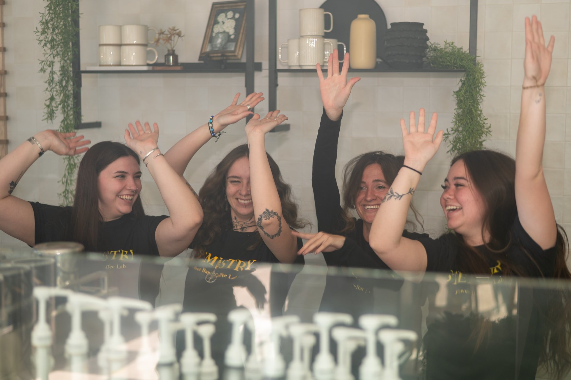 The Stemistry team throwing their hands up behind the bar