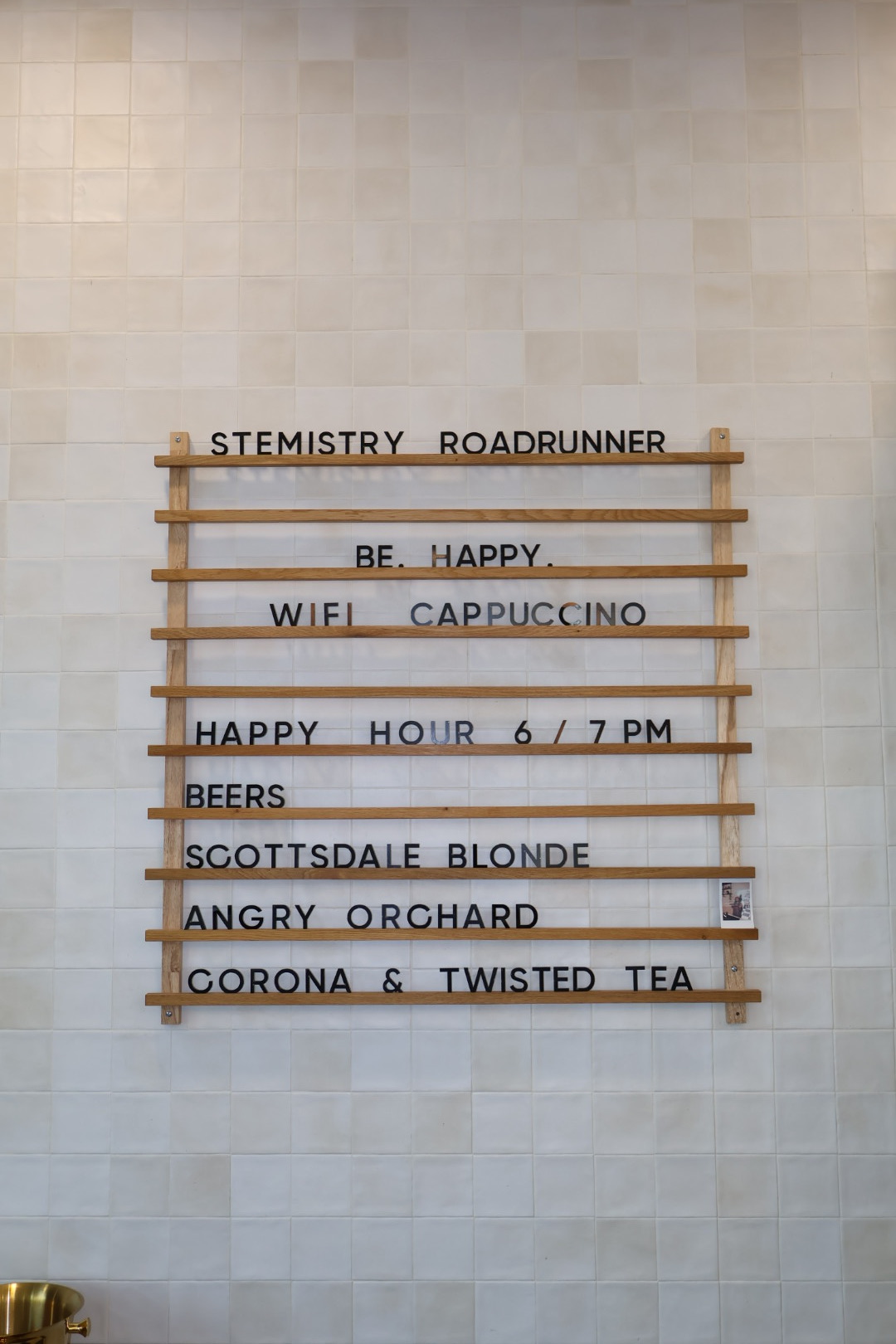 The hand-set letter board at Stemistry South Scottsdale listing happy hour and the beer lineup