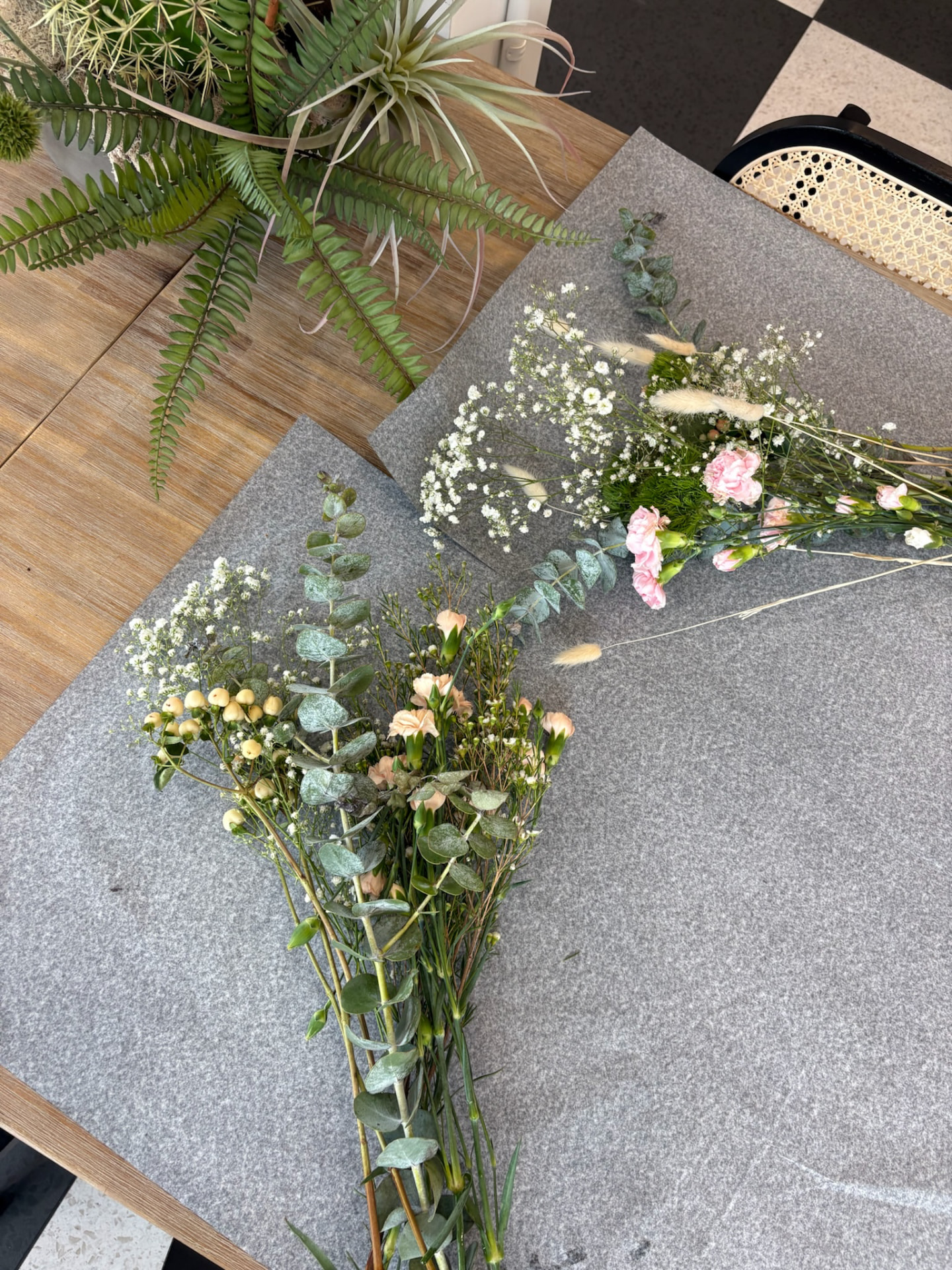 Eucalyptus, baby's breath and carnations laid out on wrapping paper